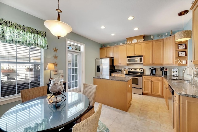 kitchen featuring pendant lighting, appliances with stainless steel finishes, sink, and a center island