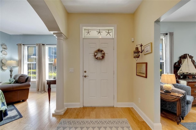 entryway with ornate columns and light hardwood / wood-style flooring