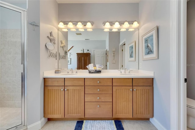 bathroom with a shower with door, vanity, toilet, and tile patterned flooring