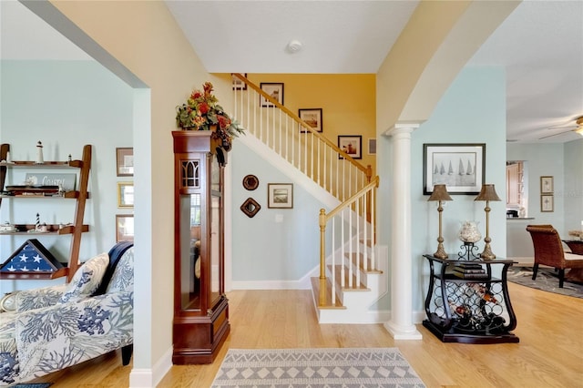 stairs featuring ceiling fan, hardwood / wood-style floors, and ornate columns