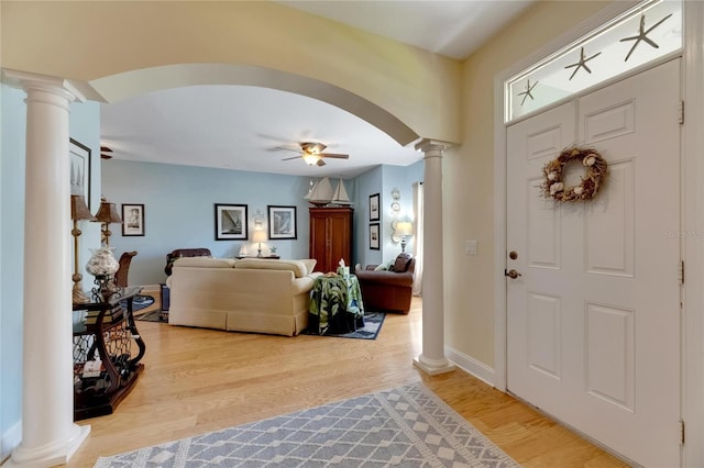 entrance foyer with ornate columns, hardwood / wood-style floors, and ceiling fan