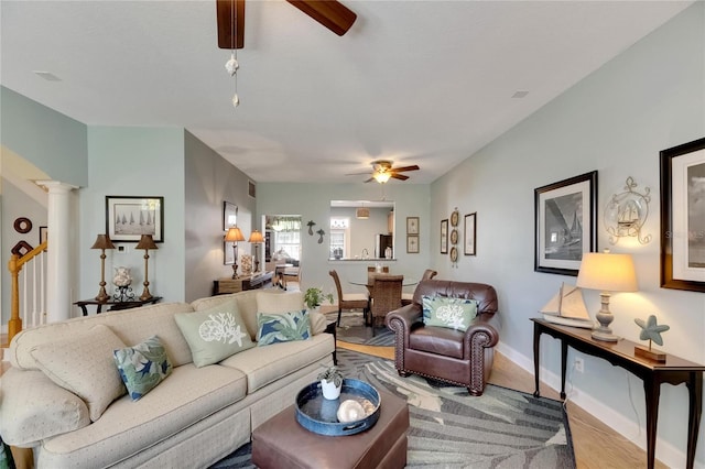 living room with ceiling fan, ornate columns, and light hardwood / wood-style flooring