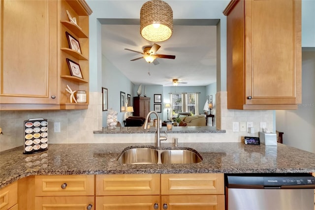 kitchen featuring dishwasher, decorative backsplash, dark stone counters, and sink