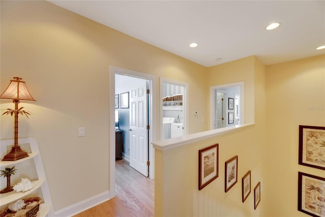 corridor featuring light wood-type flooring and washer and clothes dryer