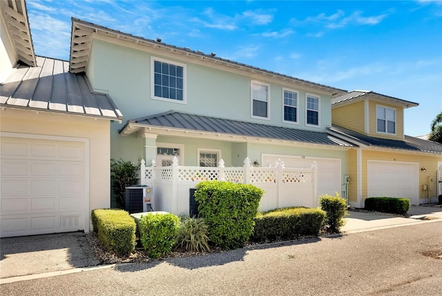 view of front of house featuring a garage and cooling unit