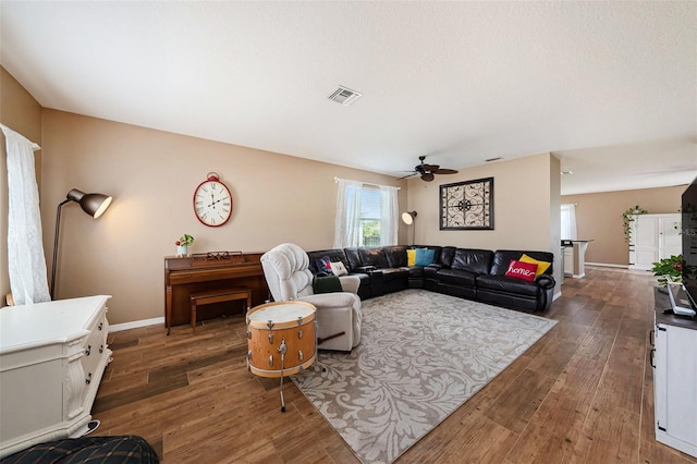 living room featuring dark hardwood / wood-style flooring and ceiling fan