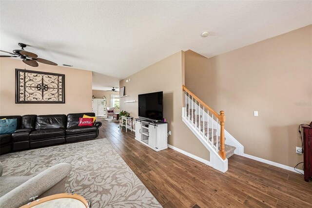 living room featuring ceiling fan, a textured ceiling, lofted ceiling, and dark wood-type flooring