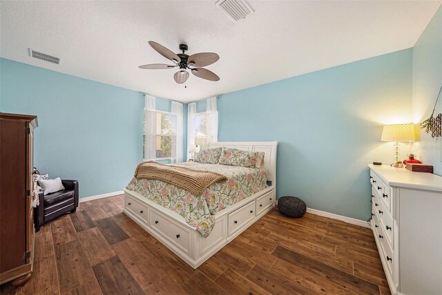 bedroom featuring ceiling fan, dark wood-type flooring, and a textured ceiling