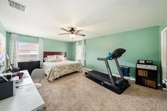 bedroom with ceiling fan, a textured ceiling, and carpet flooring