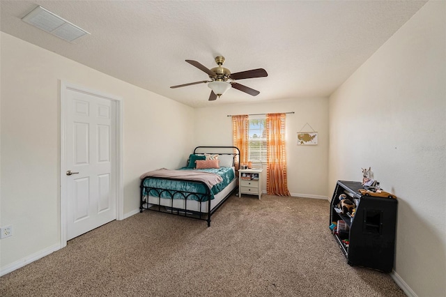 bedroom featuring ceiling fan, carpet floors, and a textured ceiling