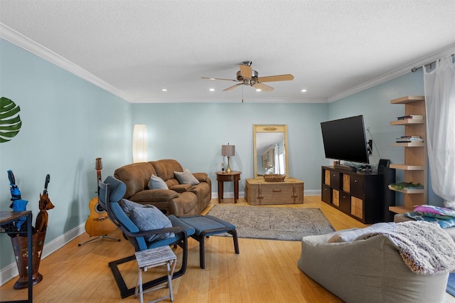 living room with ceiling fan, ornamental molding, a textured ceiling, and light hardwood / wood-style floors