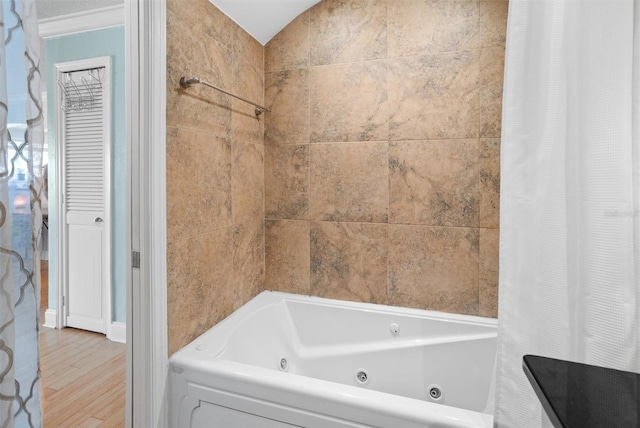 bathroom featuring wood-type flooring and shower / tub combo with curtain