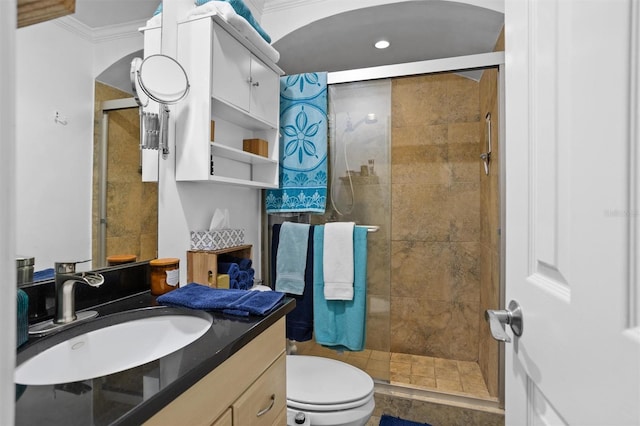 bathroom with tile patterned flooring, an enclosed shower, crown molding, vanity, and toilet