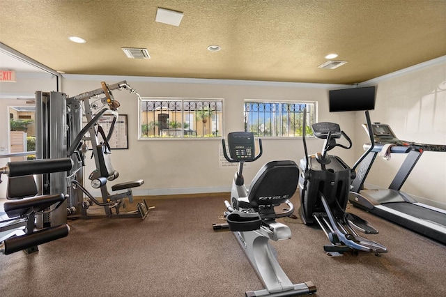 gym with ornamental molding and a textured ceiling