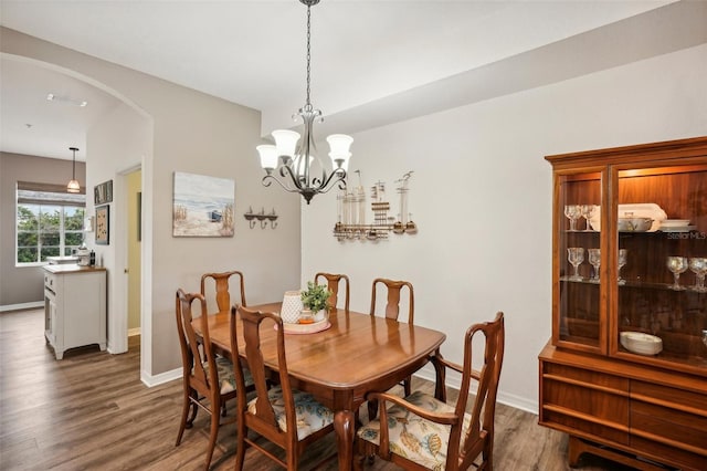 dining area with a chandelier and dark hardwood / wood-style flooring