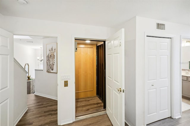 hallway with hardwood / wood-style floors