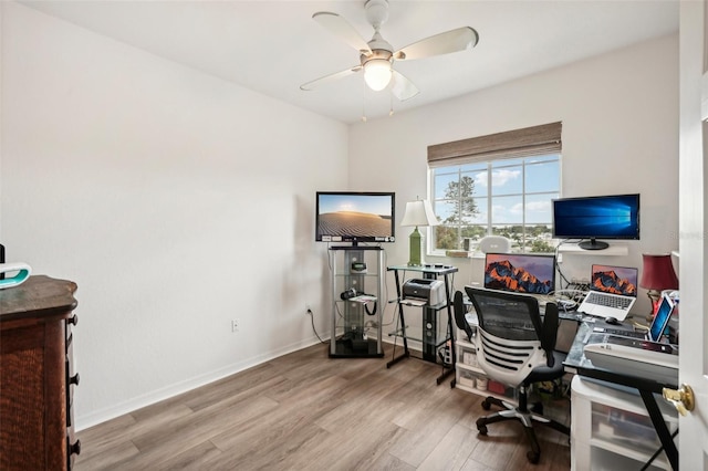 home office with light hardwood / wood-style flooring and ceiling fan