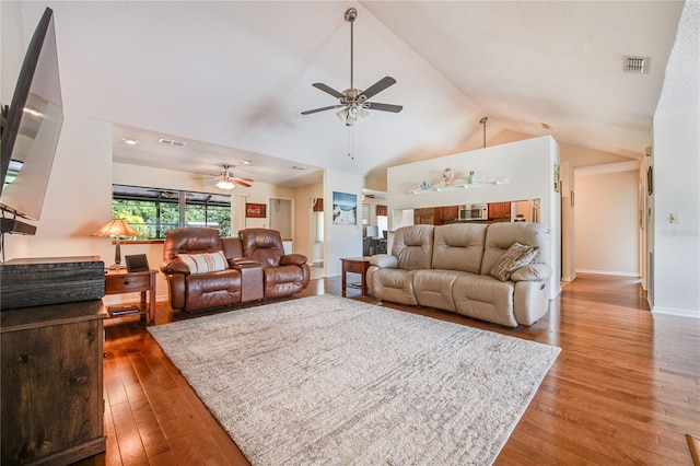 living room featuring dark hardwood / wood-style floors, high vaulted ceiling, and ceiling fan