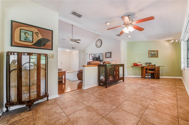 interior space with a textured ceiling, high vaulted ceiling, and ceiling fan