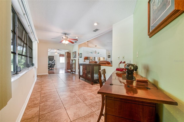 interior space featuring ceiling fan, a textured ceiling, and vaulted ceiling