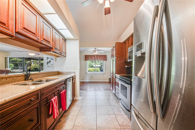 kitchen featuring sink, a textured ceiling, stainless steel appliances, light stone counters, and light tile patterned floors