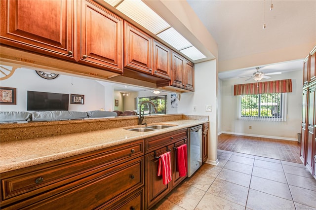 kitchen featuring dishwasher, sink, light stone countertops, light wood-type flooring, and ceiling fan