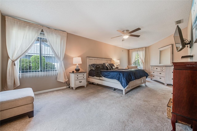 carpeted bedroom featuring a textured ceiling and ceiling fan