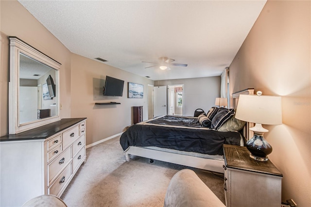 bedroom with ceiling fan, a textured ceiling, and light colored carpet