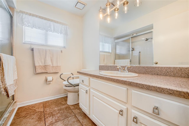 bathroom featuring vanity, toilet, a healthy amount of sunlight, and a shower with shower door