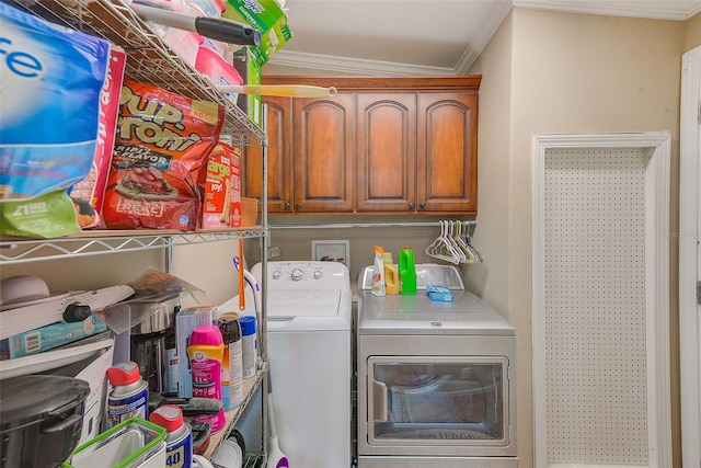 laundry room with crown molding, washer and clothes dryer, and cabinets