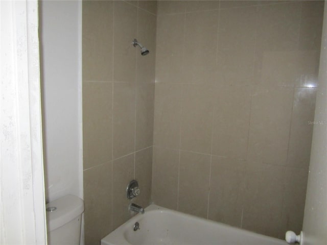 bathroom with tiled shower / bath combo and toilet