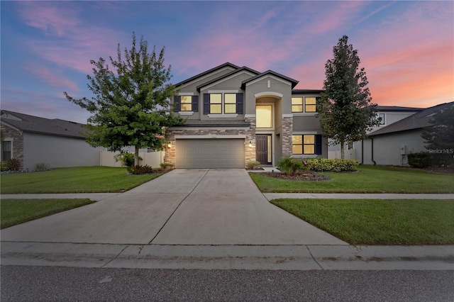 traditional home with a lawn, stucco siding, stone siding, and driveway
