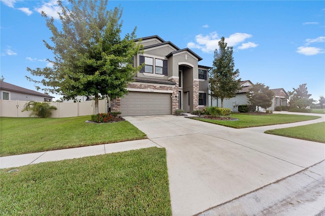 traditional home with fence, a garage, concrete driveway, stone siding, and a front lawn