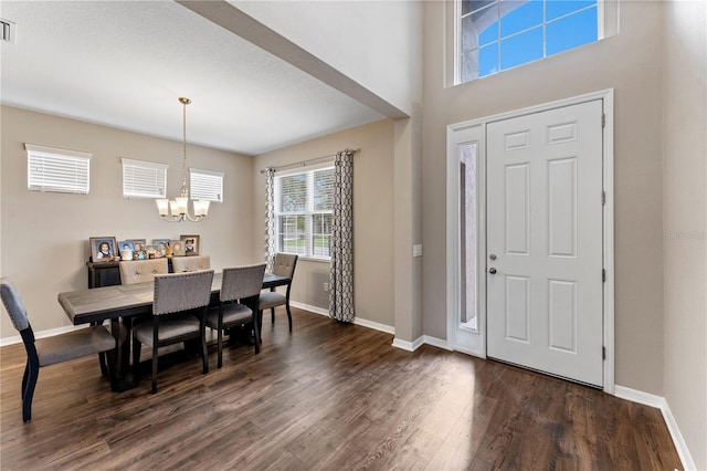 entryway with an inviting chandelier and dark hardwood / wood-style floors