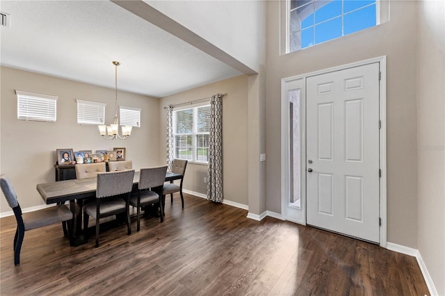 entrance foyer with a notable chandelier, dark wood-type flooring, baseboards, and visible vents