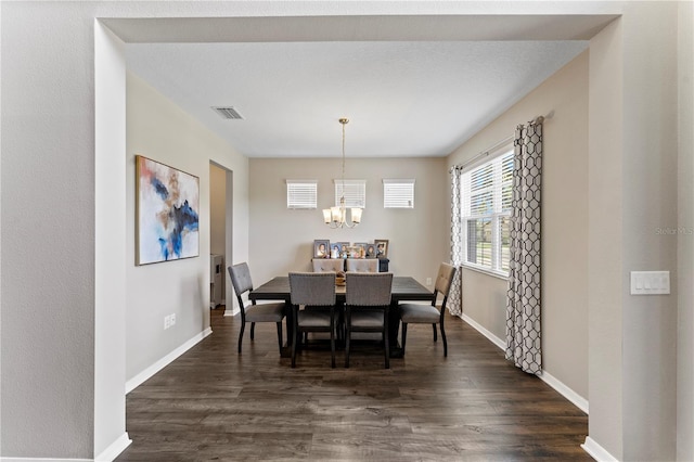 dining area with dark hardwood / wood-style floors and a chandelier