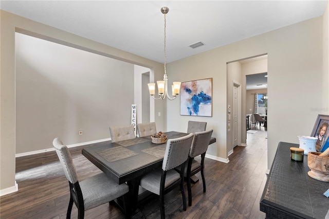 dining area with baseboards, a notable chandelier, dark wood-type flooring, and visible vents
