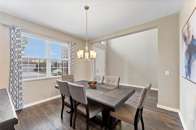 dining area featuring a notable chandelier, baseboards, and dark wood finished floors