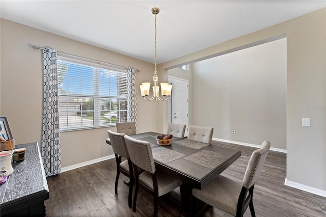 dining space featuring baseboards, dark wood-style flooring, and a notable chandelier