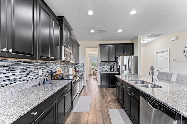 kitchen featuring dark cabinetry, visible vents, appliances with stainless steel finishes, and a sink
