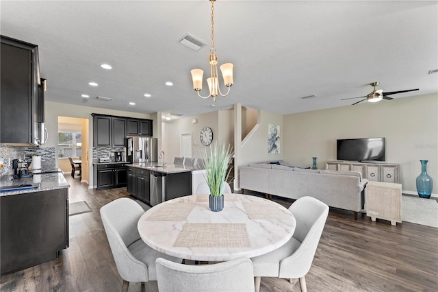 dining room featuring a textured ceiling, ceiling fan with notable chandelier, dark hardwood / wood-style floors, and sink