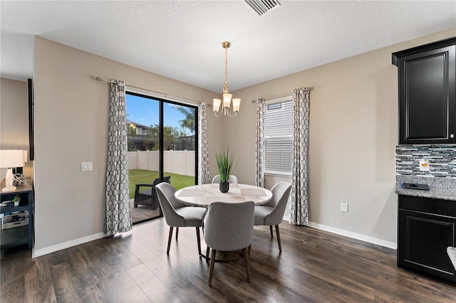 dining room with dark hardwood / wood-style flooring and a chandelier