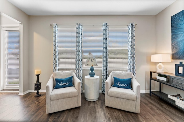 sitting room with baseboards, a healthy amount of sunlight, and wood finished floors