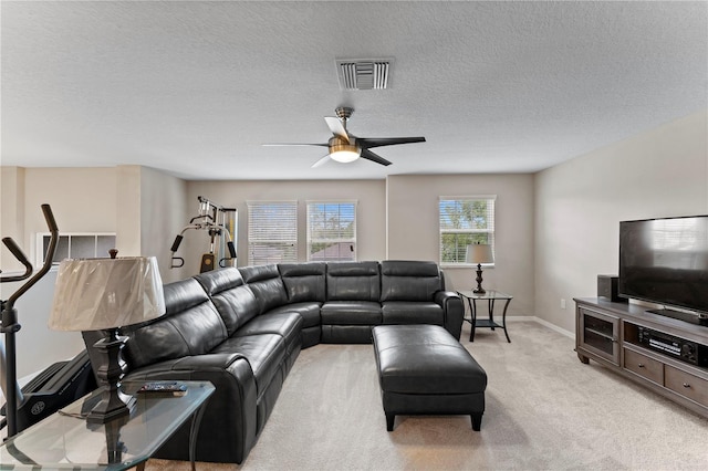 living room featuring a textured ceiling, ceiling fan, and light carpet