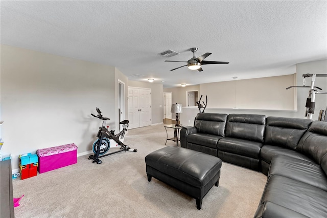 carpeted living room with a textured ceiling and ceiling fan