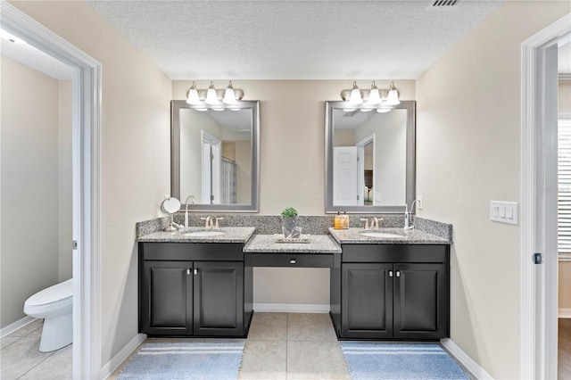 bathroom featuring a textured ceiling, tile patterned flooring, vanity, and toilet