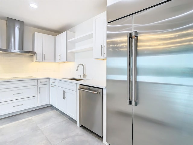 kitchen featuring sink, white cabinets, stainless steel appliances, and wall chimney exhaust hood