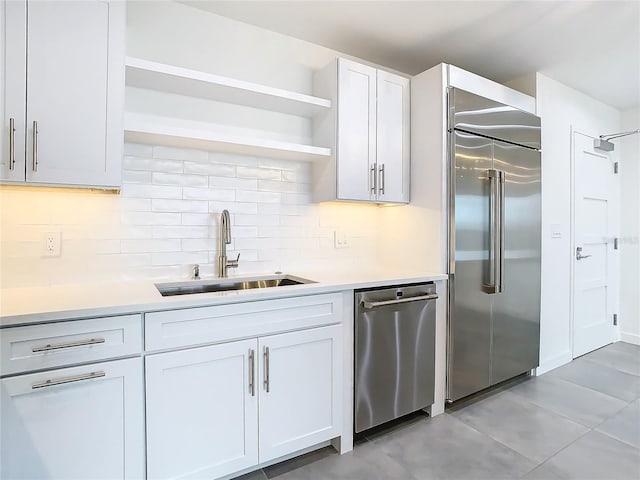 kitchen featuring stainless steel appliances, white cabinetry, tasteful backsplash, and sink