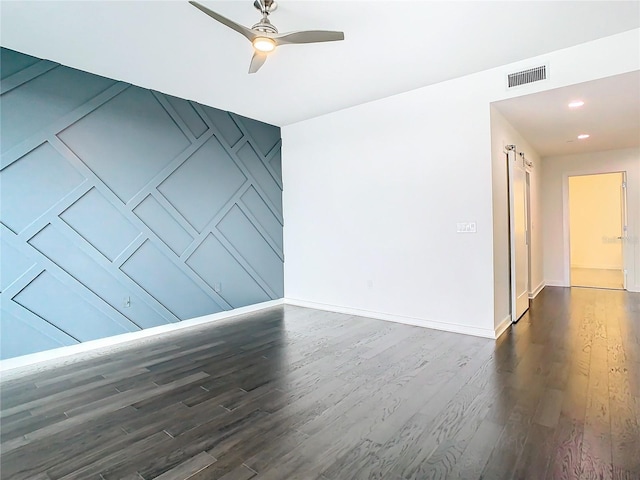 empty room with ceiling fan and dark hardwood / wood-style floors