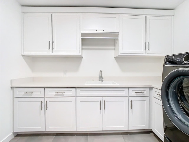 laundry area featuring washer / clothes dryer, light tile patterned flooring, sink, and cabinets